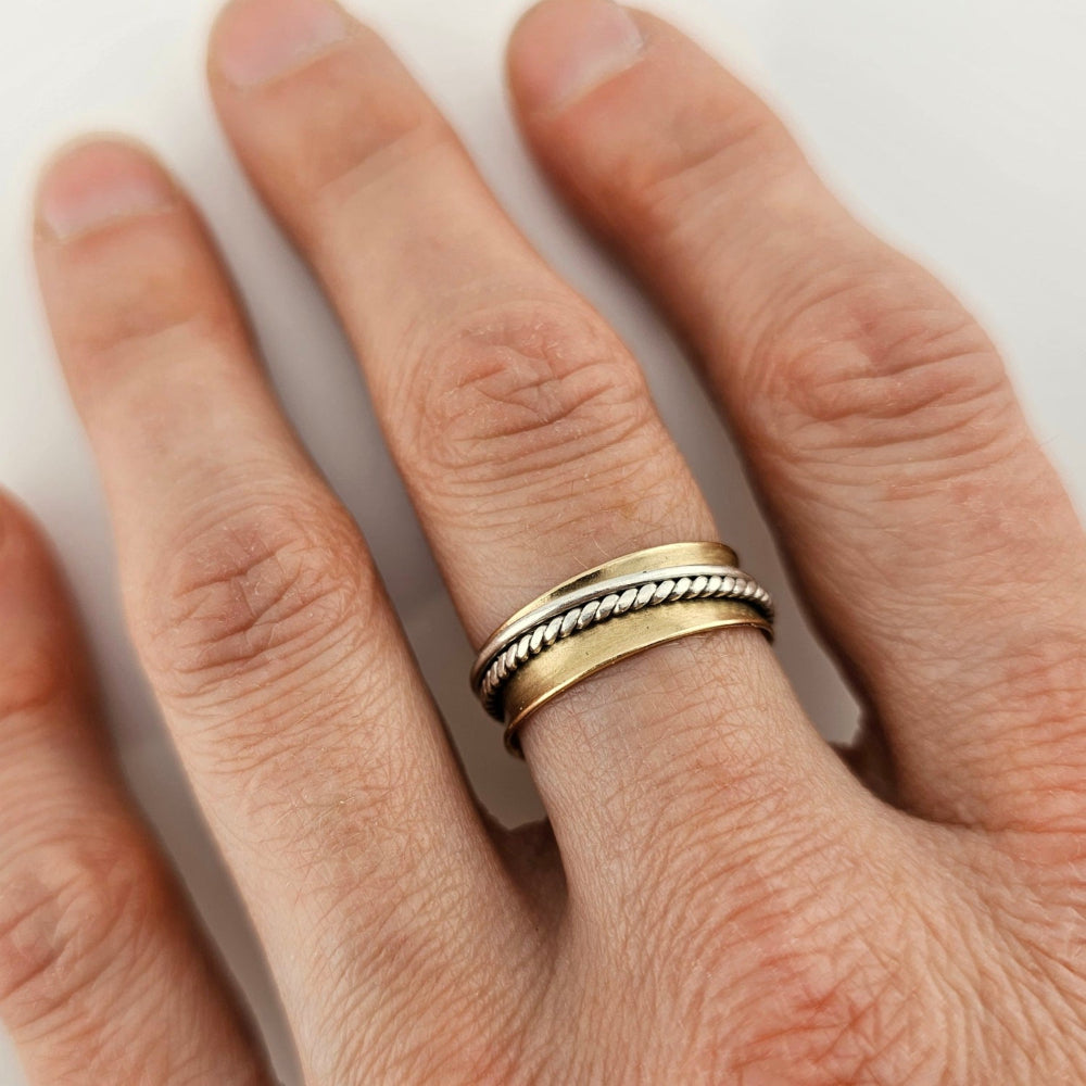 14K Gold spinner anxiety ring on a woman's middle finger.