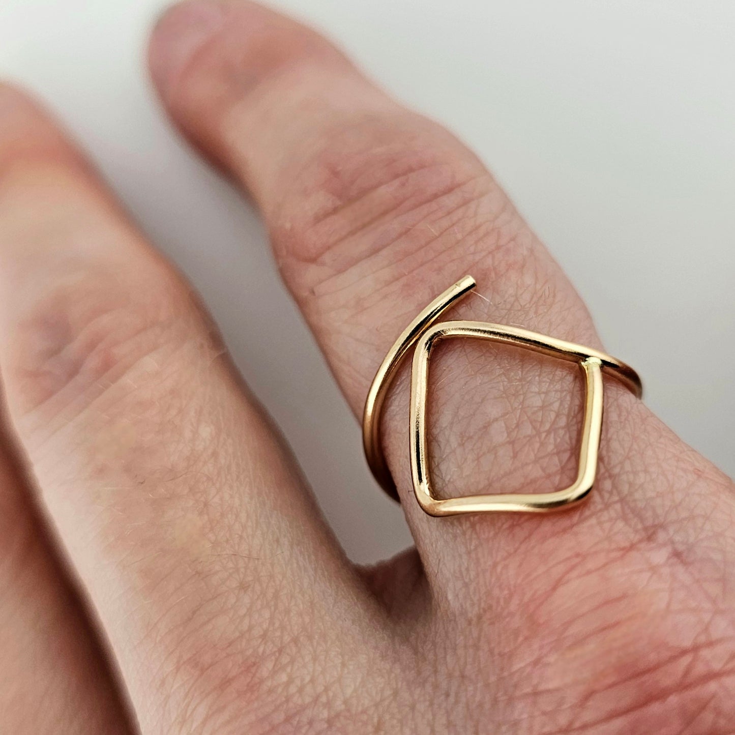 Adjustable Gold Ring with Square feature on woman's finger. 