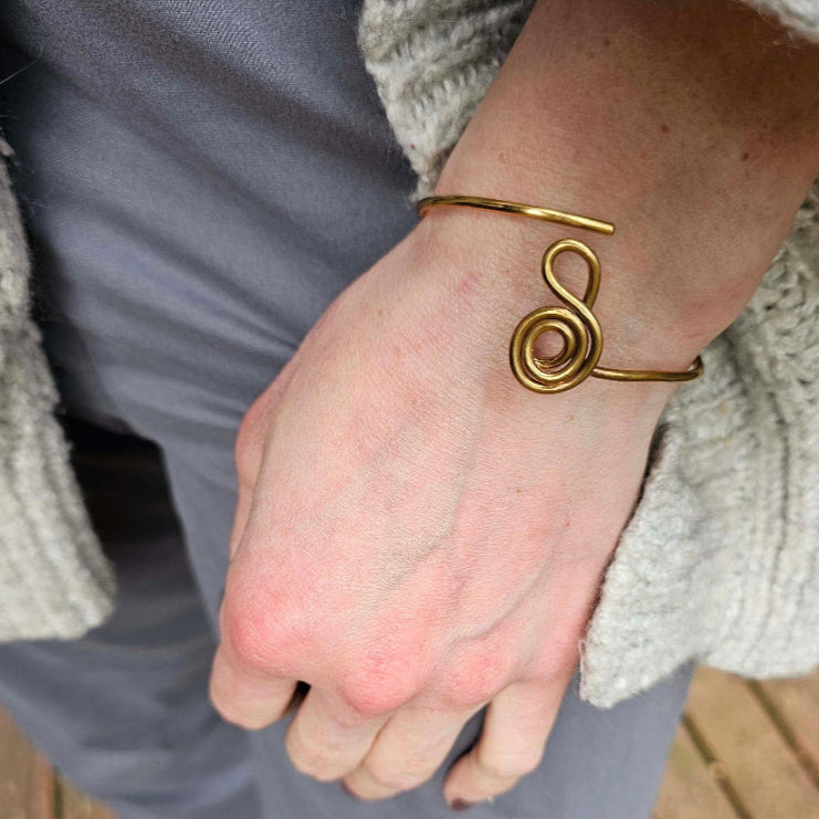 Gold Gratitude Symbol Bracelet on woman's wrist.