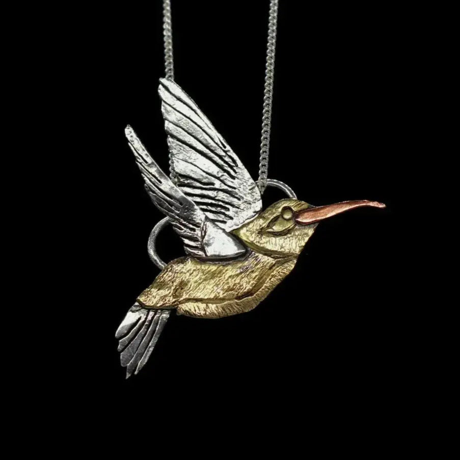 Custom bird necklace by jewelry designer Jaclyn Nicole displayed on a black background.