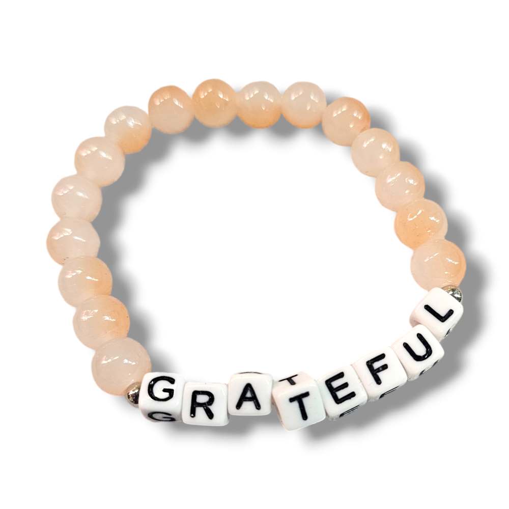 Orange glass bead affirmation bracelets featuring the word "grateful".