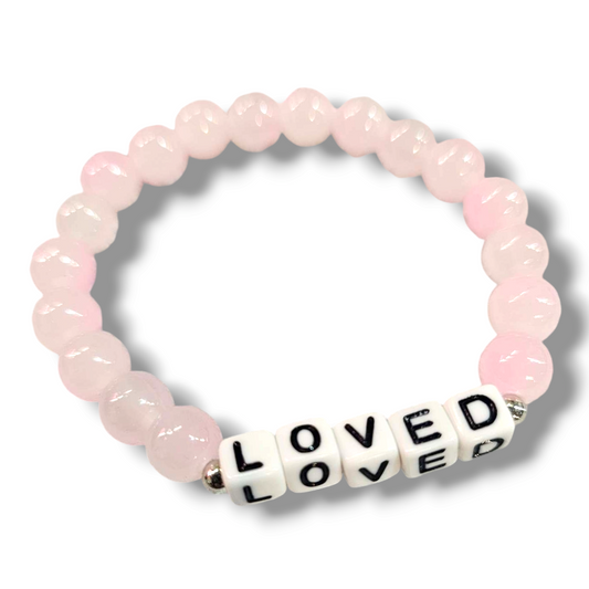 Pink glass bead affirmation bracelet featuring the word "loved".