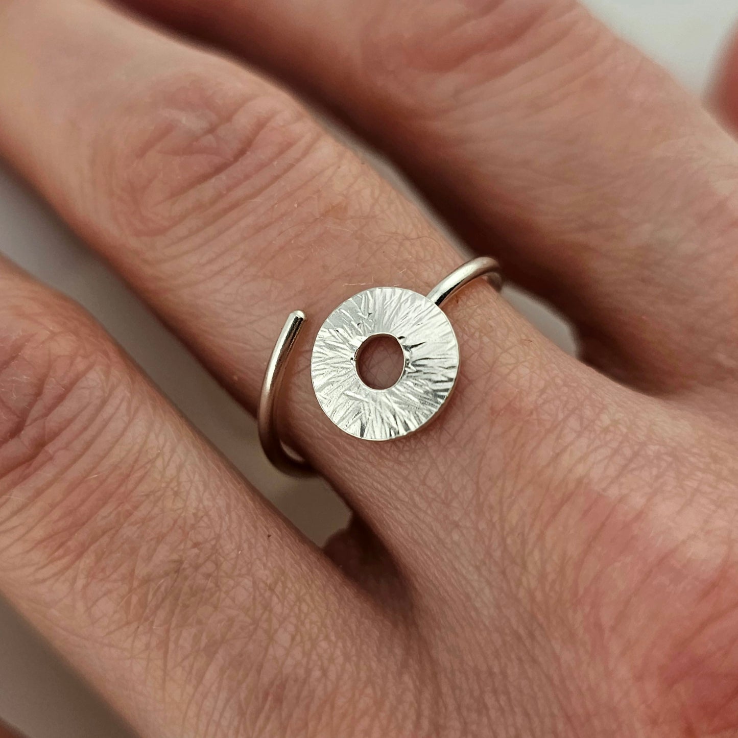 Close up of a silver Adjustable Manifestation ring on woman's hand