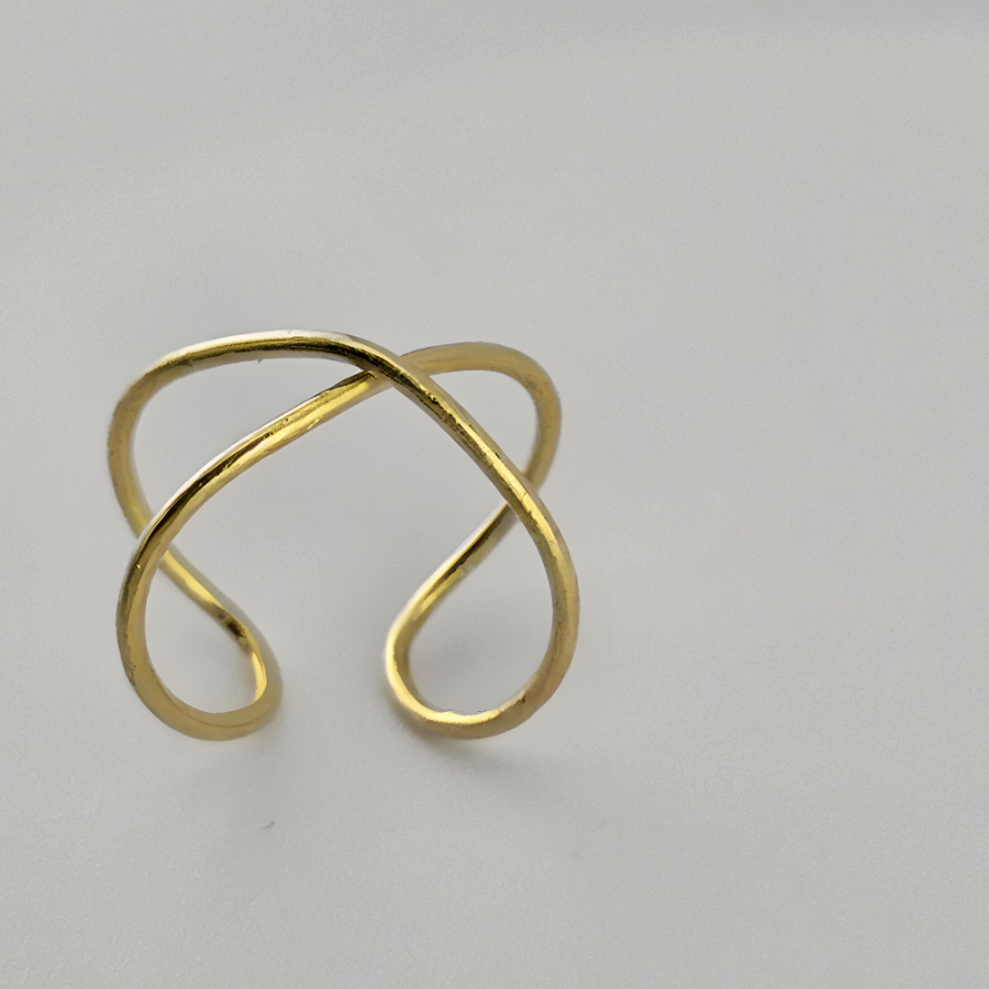 14K yellow gold infinity ring with grey background.