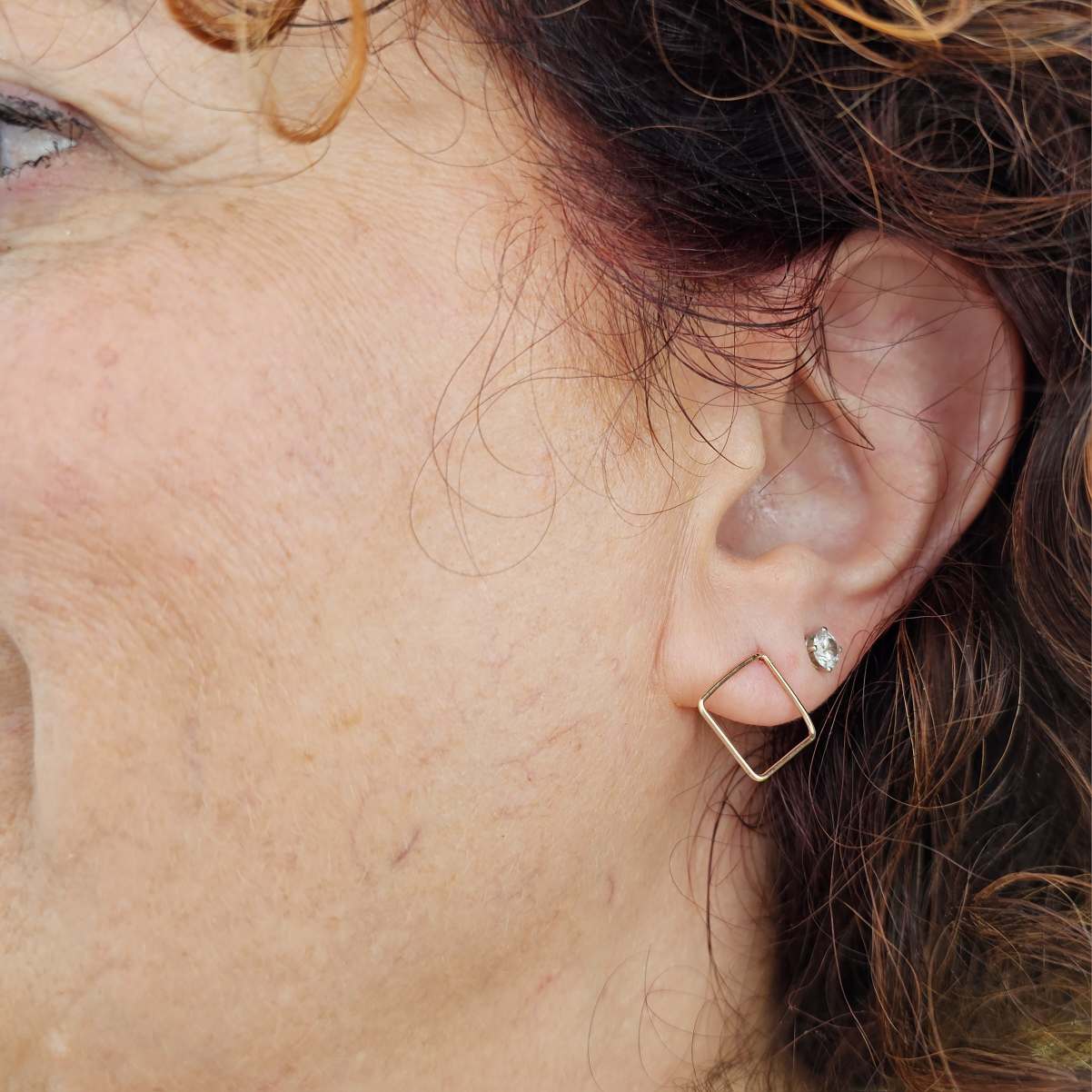 Woman with red curly hair wearing Square Gold Stud Earrings.