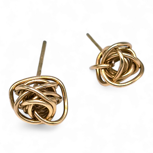 Close up of a pair of Gold Handmade knot earrings on a white background.