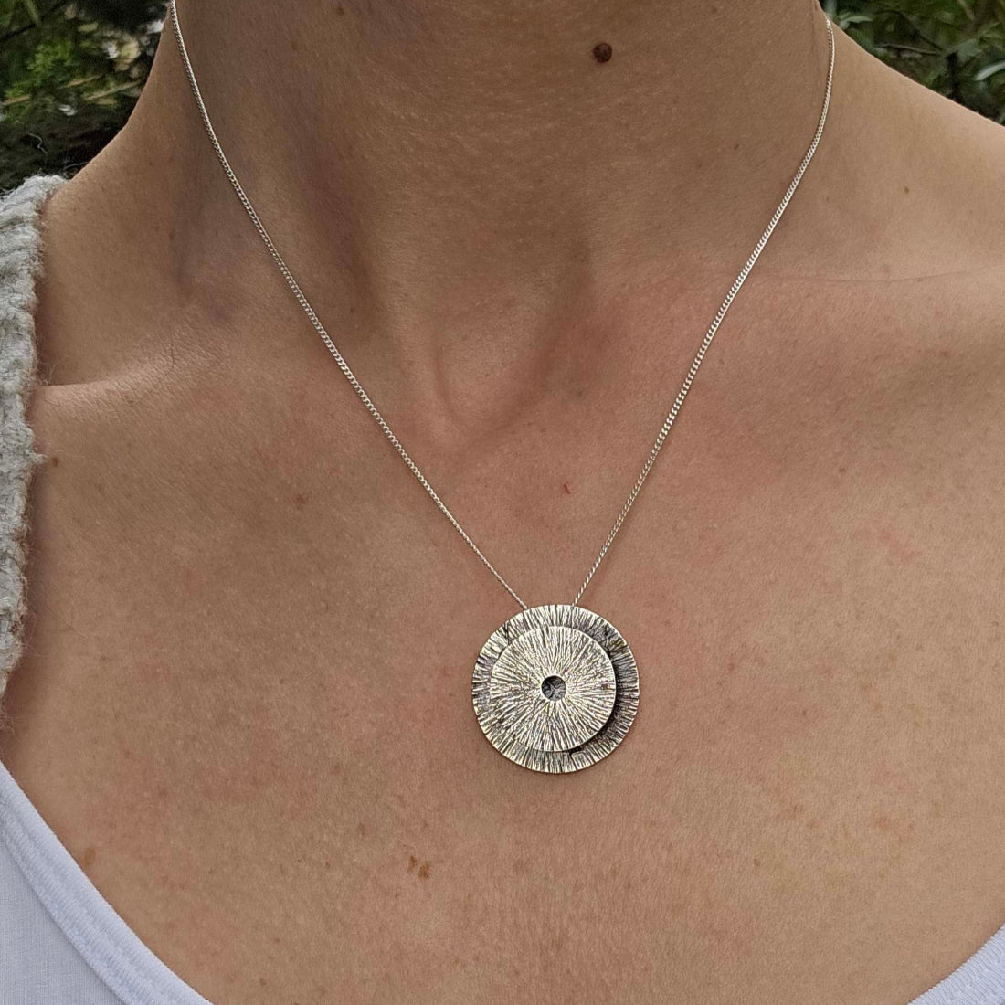 a woman wearing a sterling silver vessel manifestation necklace