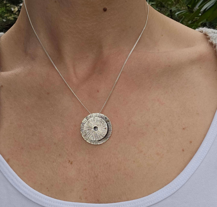 a woman wearing a sterling silver manifestation vessel necklace