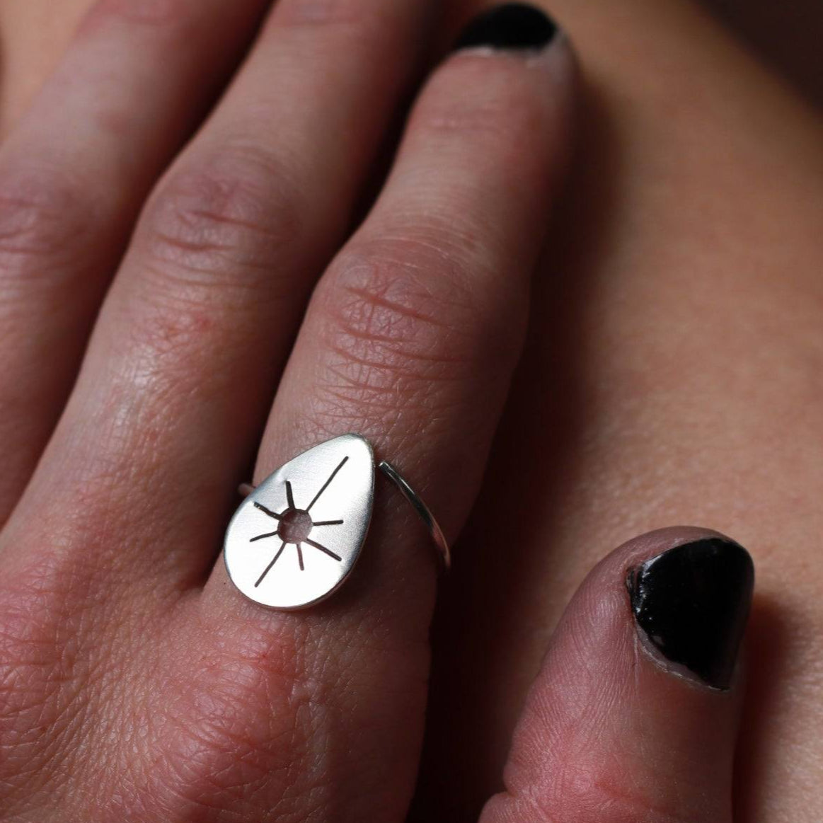 Sun drop dainty adjustable ring worn on a woman's pointer finger.