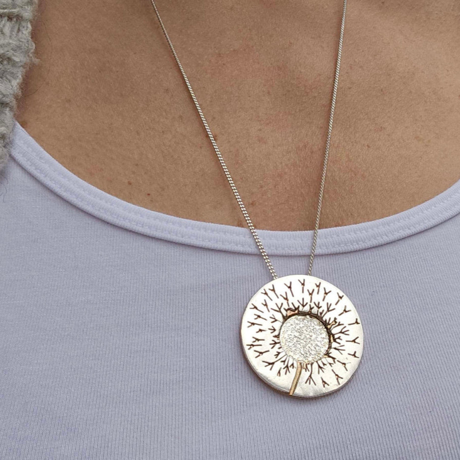 One of a kind handcrafted dandelion necklace worn around woman's neck