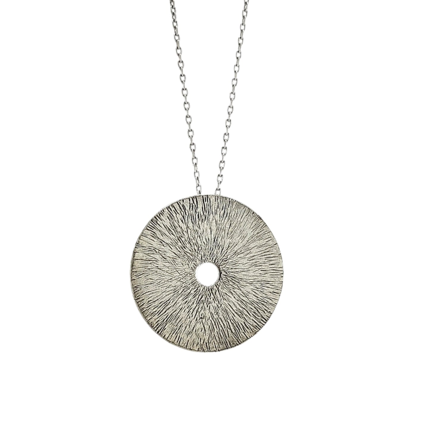 Silver manifestation necklace on chain n front of white background.