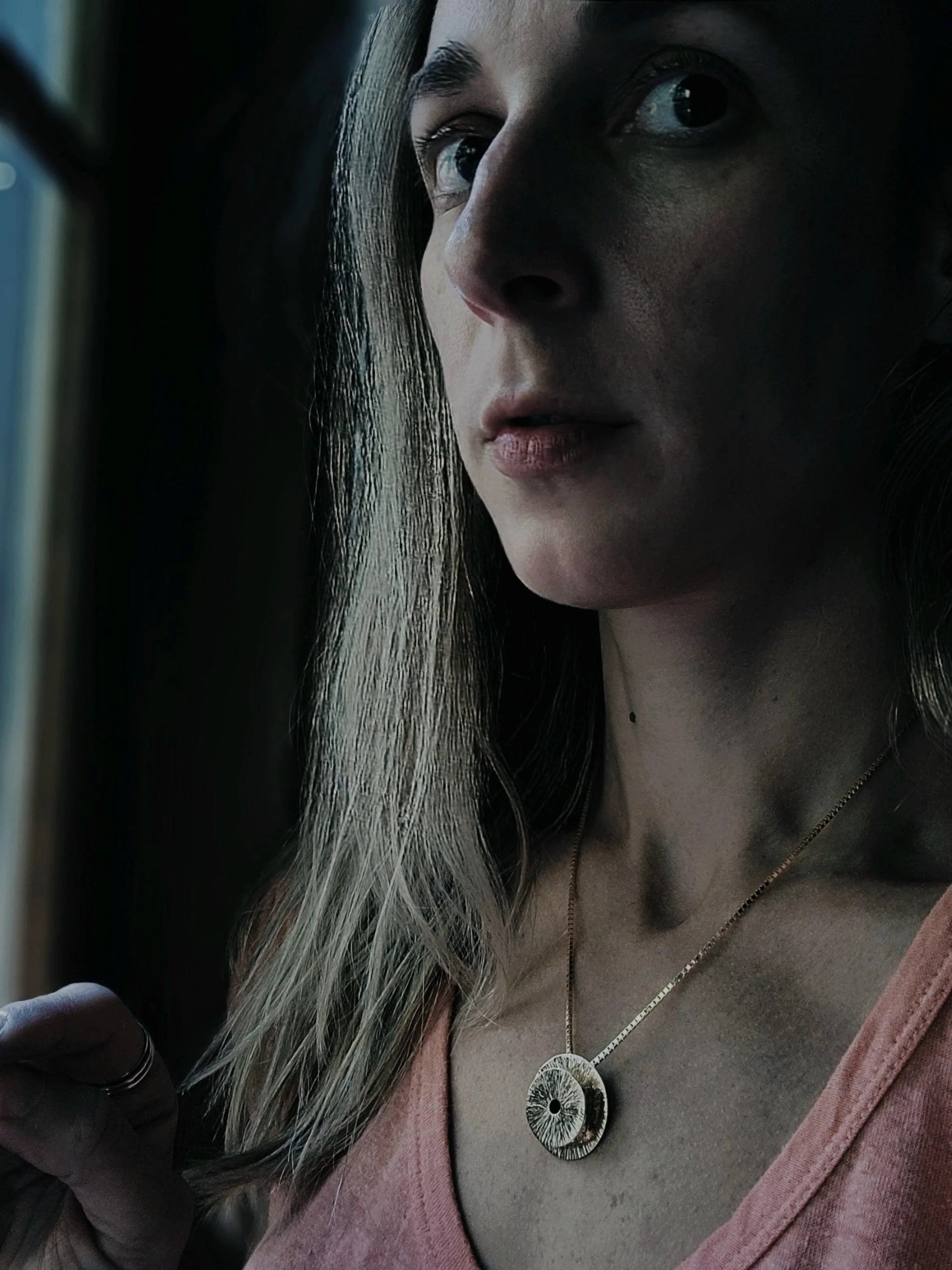 a model in darkness in a pendant necklace