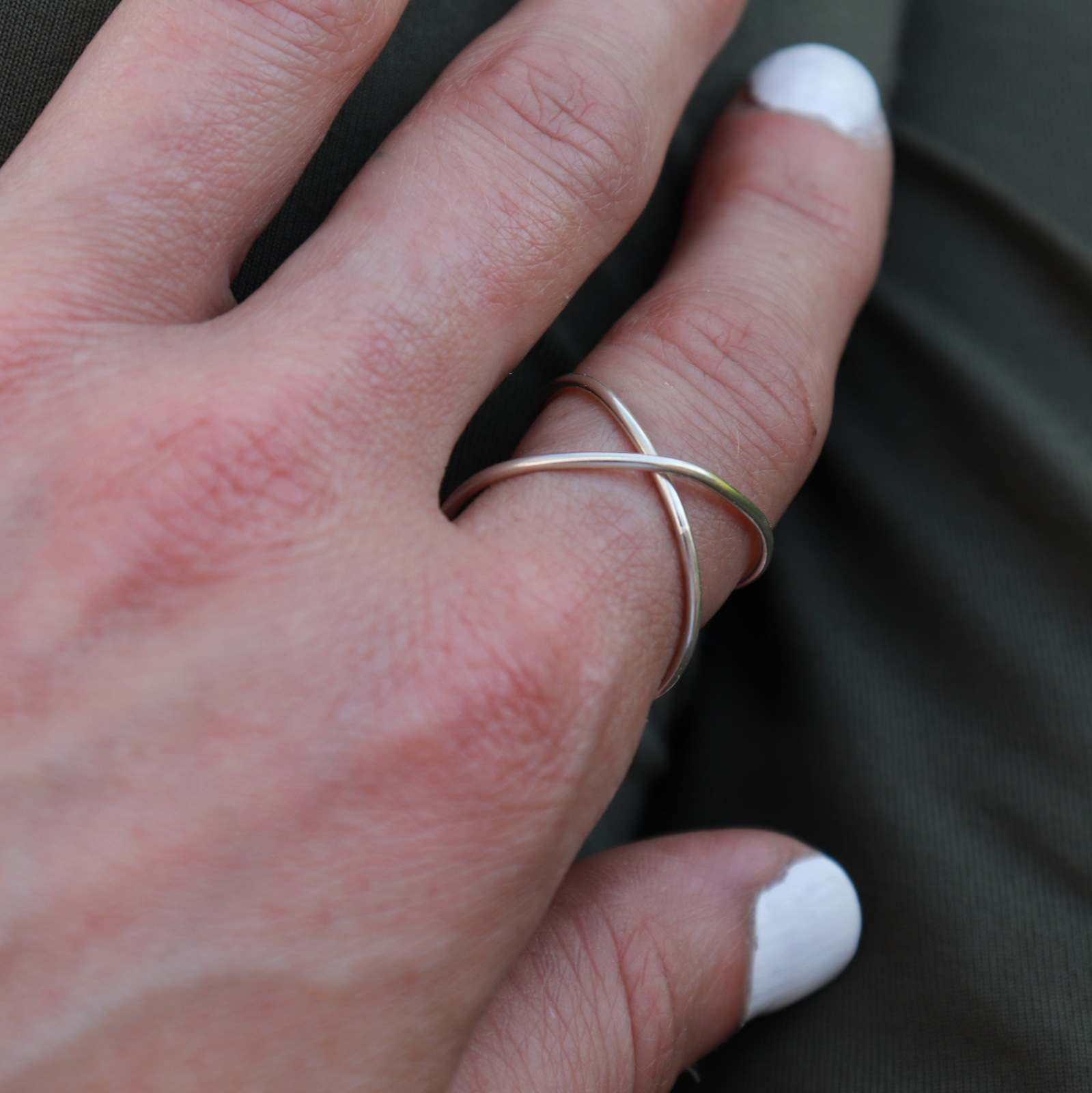 Silver Infinity Ring worn on woman's pointer finger  