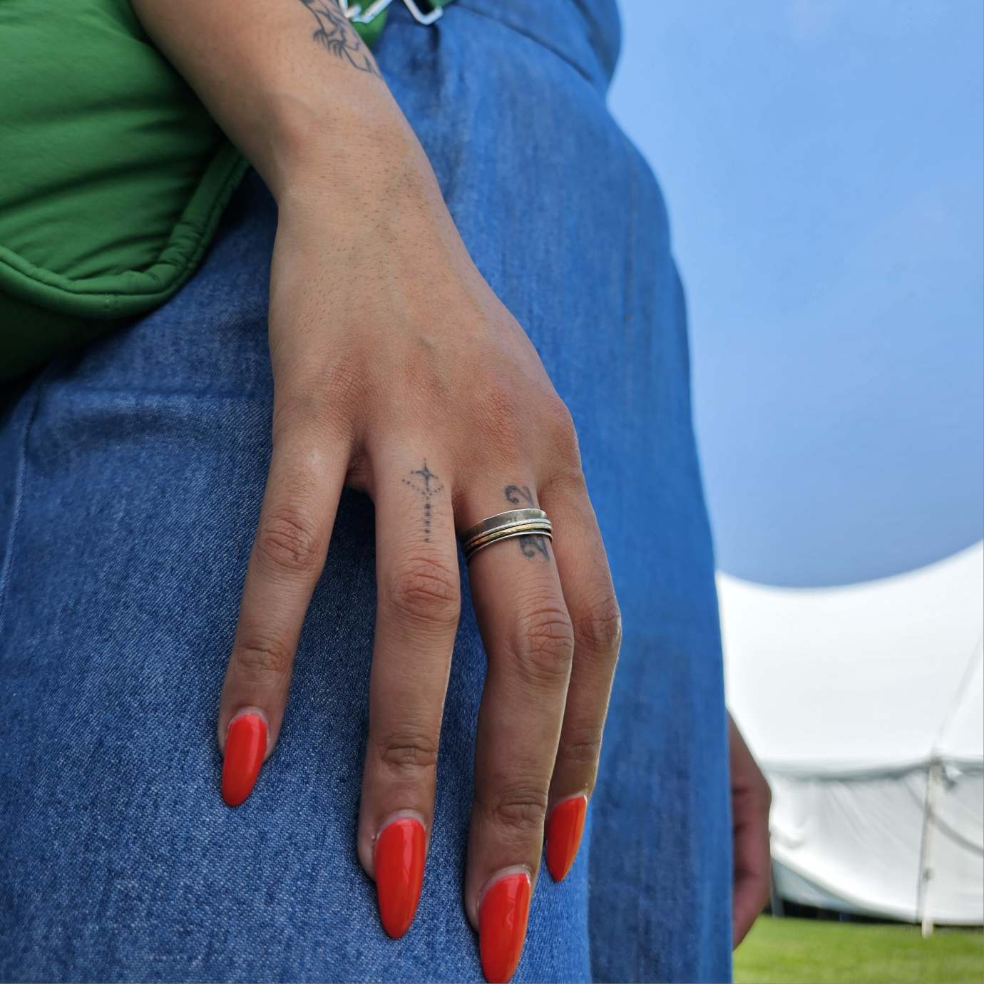 A woman's hand with a silver Spinner Ring on it with silver and gold bands