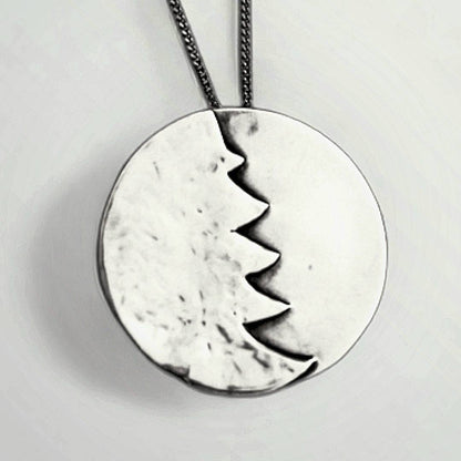 A silver Christmas tree pendant necklace.