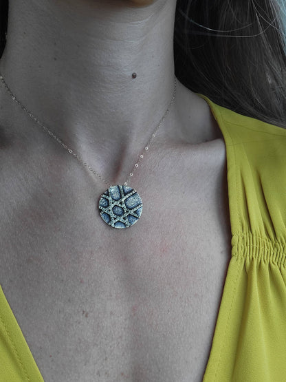 a woman in a yellow shirt and silver pendant necklace.