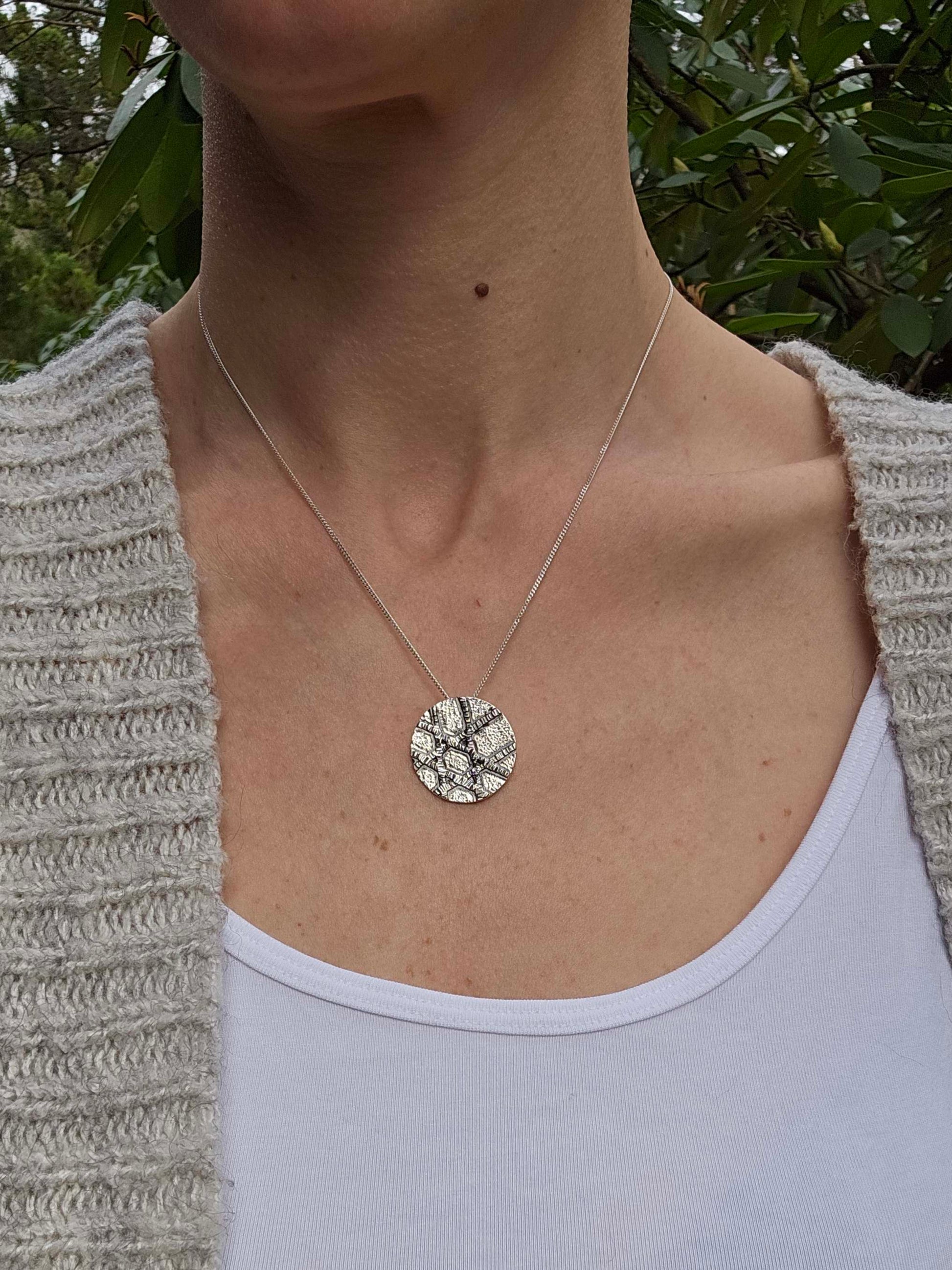 a woman wearing a silver Star of David necklace.